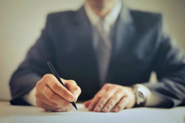 man signing paper